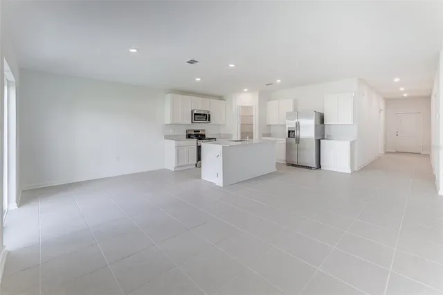 a view of a kitchen with furniture and refrigerator