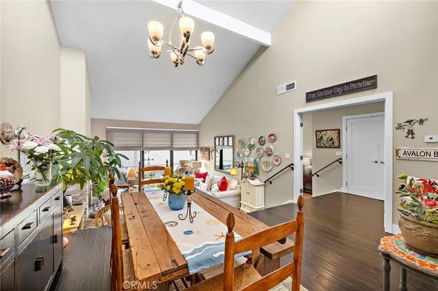 a view of a dining room with furniture a potted plant and wooden floor