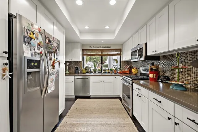 a kitchen with stainless steel appliances granite countertop a refrigerator and a sink