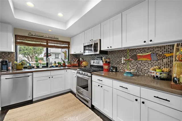 a kitchen with granite countertop white cabinets and white appliances
