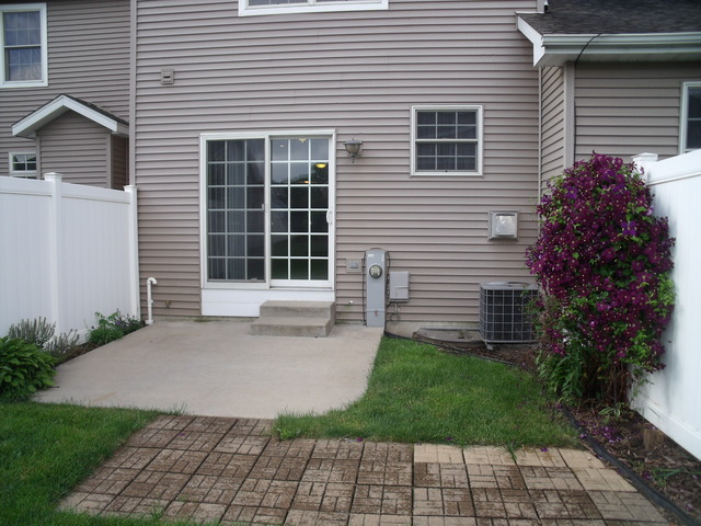 2123 Autumn Lane, Unit 2123 DeKalb, IL 60115 - Photo 12 of 12 a front view of a house with a yard and a garden