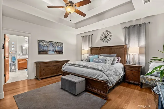 a bedroom with a large bed and a chandelier fan
