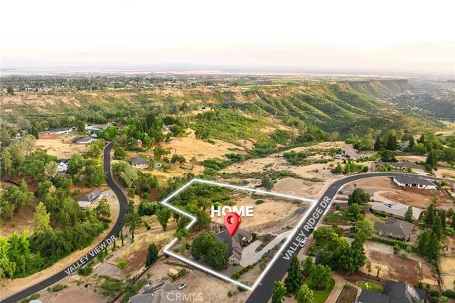 an aerial view of a house with a garden and lake view