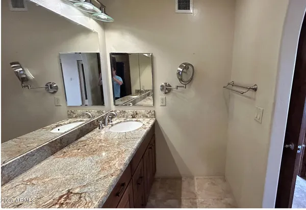 a bathroom with a granite countertop sink and a mirror