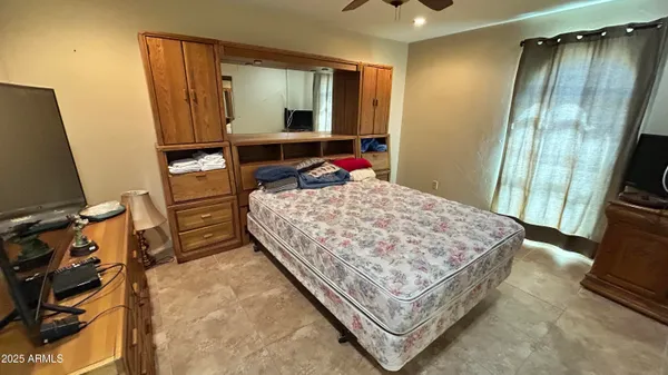 a bed sitting in a bedroom next to a window