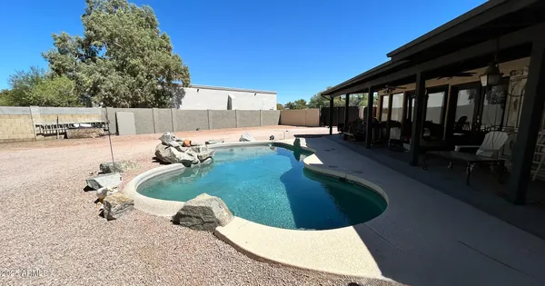 a swimming pool with outdoor seating and yard