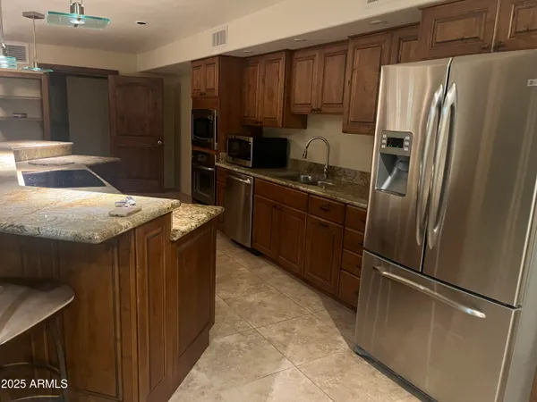 a kitchen with granite countertop a refrigerator and a sink
