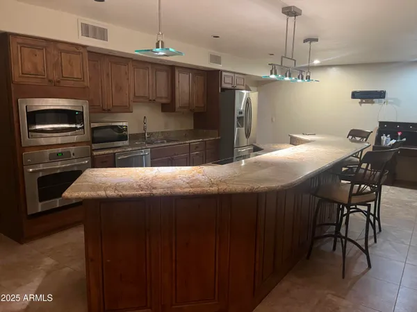 a kitchen with kitchen island a counter space a sink appliances and cabinets