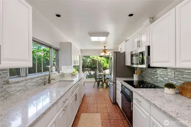 a kitchen with granite countertop a sink and a stove top oven