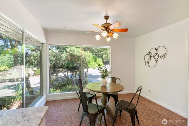 a dining room with furniture a large window and a rug