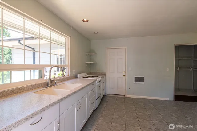 a spacious bathroom with a granite countertop sink and a large mirror