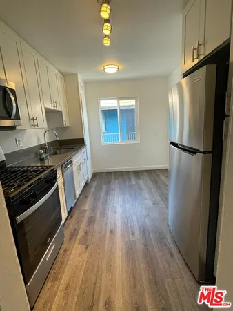 a kitchen with wooden floors and appliances