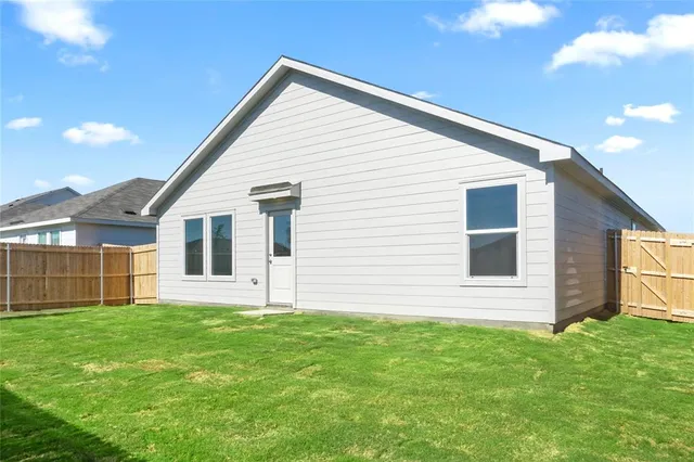 a view of a backyard with table and chairs and wooden fence