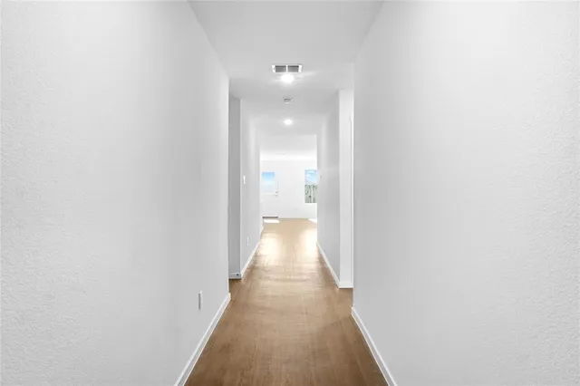 a view of a hallway with wooden floor