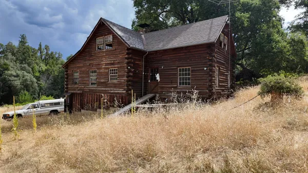 a backyard of a house with table and chairs