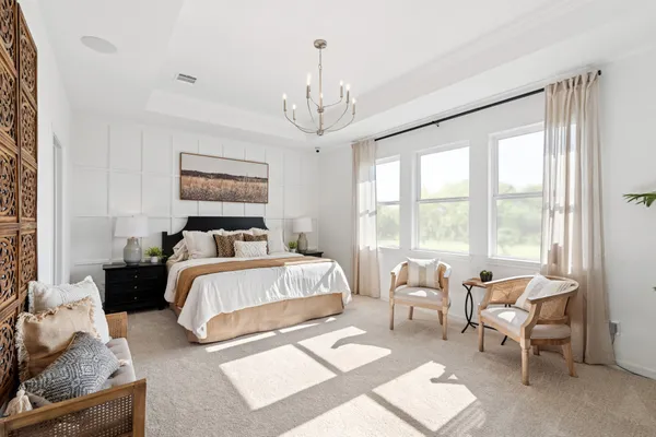 a bedroom with a bed and a chandelier