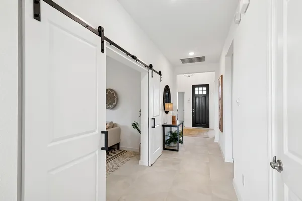 a view of a hallway with furniture and a livingroom view