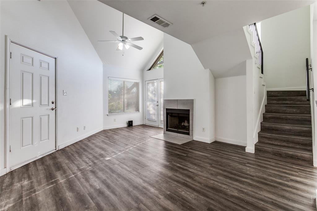 9829 Walnut Street, Unit 210 Dallas, TX 75243 - Photo 2 of 19 a view of an empty room with wooden floor fireplace and a window