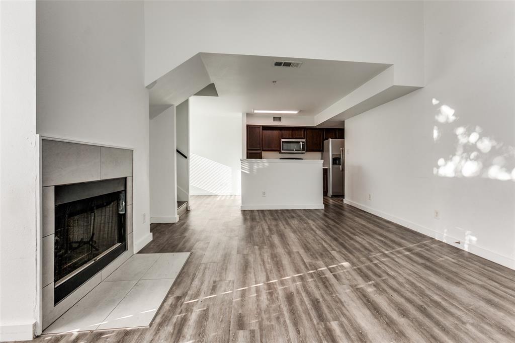 9829 Walnut Street, Unit 210 Dallas, TX 75243 - Photo 4 of 19 a view of empty room with wooden floor and fireplace
