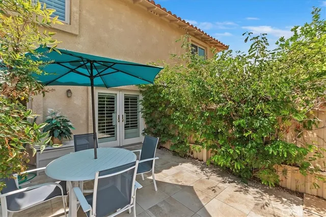 a view of an outdoor space with table and chairs under an umbrella