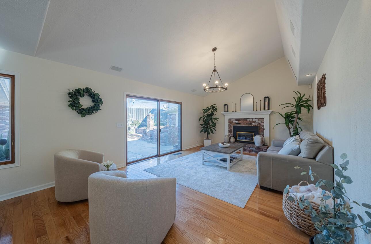 1527 Atherton Way Salinas, CA 93906 - Photo 18 of 64 a living room with furniture a fireplace and a chandelier