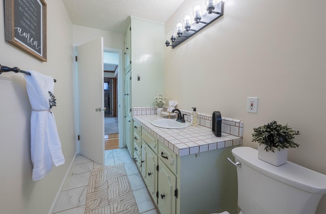 1527 Atherton Way Salinas, CA 93906 - Photo 52 of 64 a bathroom with a sink a toilet a mirror and shower