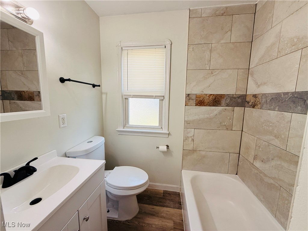 5239 Arch Street Maple Heights, OH 44137 - Photo 7 of 25 Bathroom featuring dark wood-style flooring, vanity, and shower / bath combination