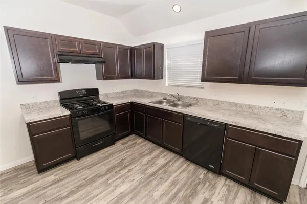 a kitchen with granite countertop stainless steel appliances and wooden cabinets