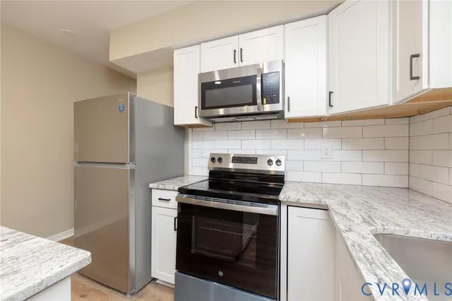 a kitchen with stainless steel appliances granite countertop a stove microwave refrigerator and sink