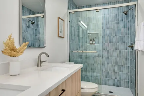 a bathroom with a sink a toilet and shower