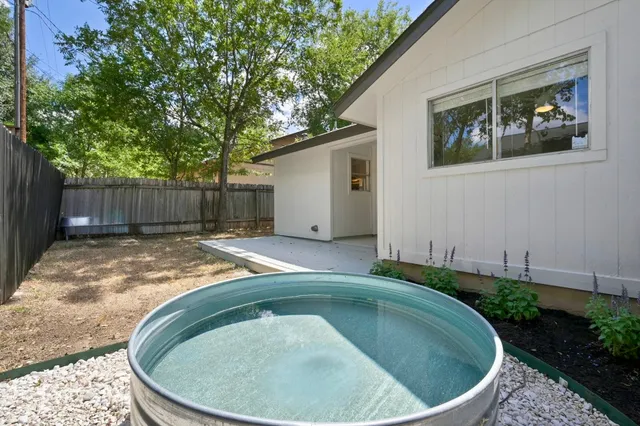 a backyard of a house with lots of green space and glass windows