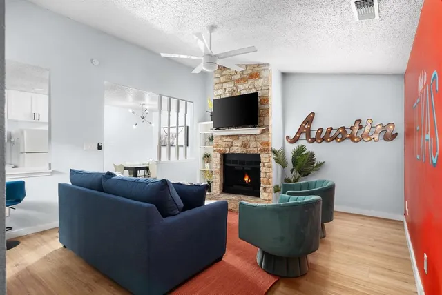 a living room with furniture a flat screen tv and a fireplace