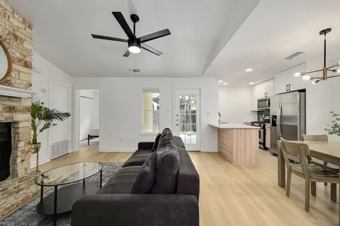a living room with furniture a ceiling fan and a rug