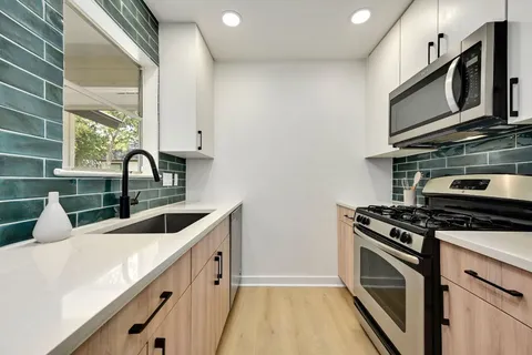 a kitchen with stainless steel appliances granite countertop a sink stove and microwave