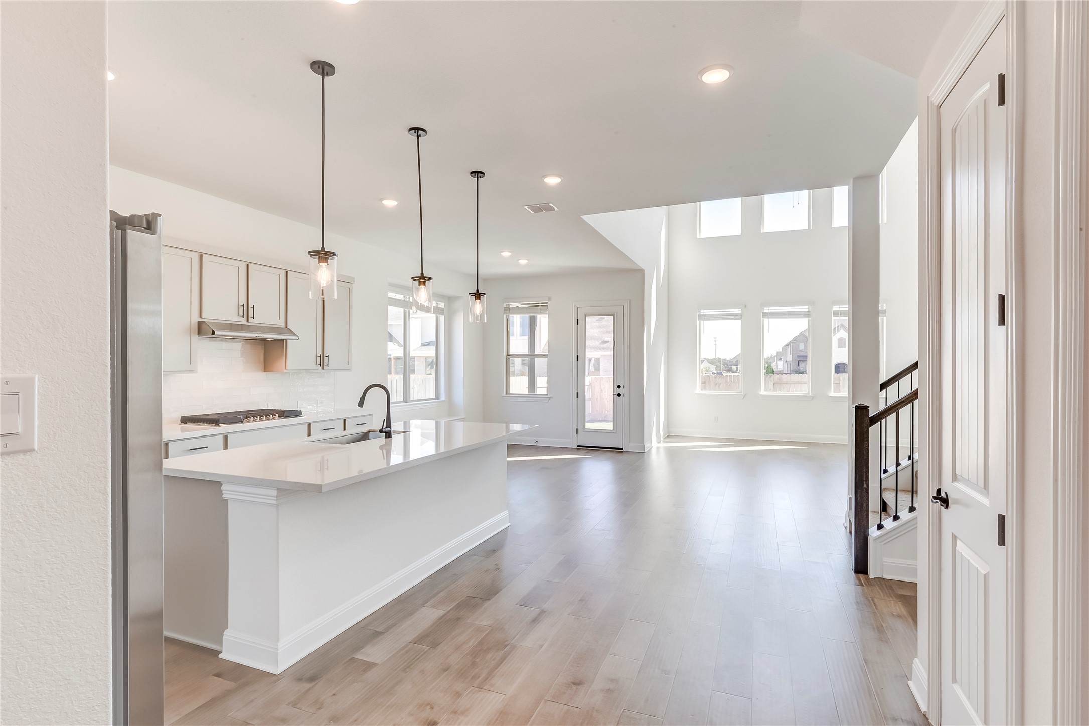 920 Old Gdn Road Leander, TX 78641 - Photo 38 of 39 Kitchen with pendant lighting, a kitchen island with sink, open floor plan, recessed lighting, and tasteful backsplash