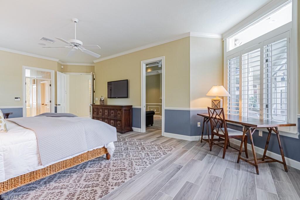 6974 Green Tree Drive Naples, FL 34108 - Photo 16 of 32 a spacious bedroom with a bed and a table in it