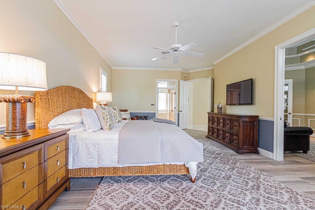 6974 Green Tree Drive Naples, FL 34108 - Photo 17 of 32 a bedroom with a large bed and a flat tv screen on dresser