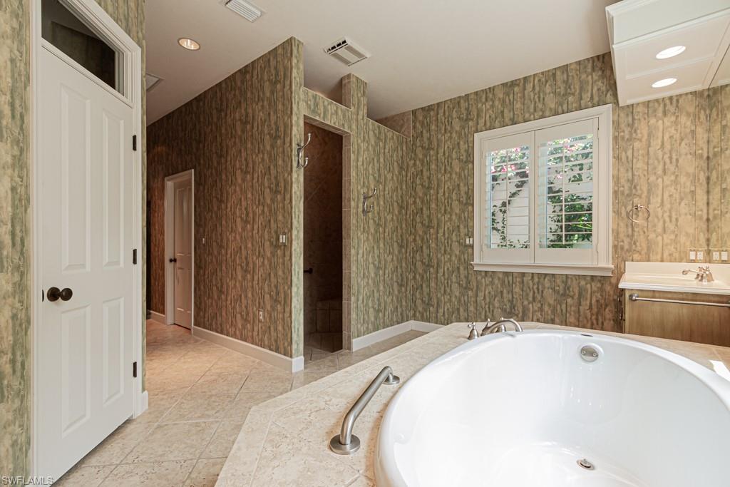 6974 Green Tree Drive Naples, FL 34108 - Photo 18 of 32 a bathroom with a bathtub and a sink