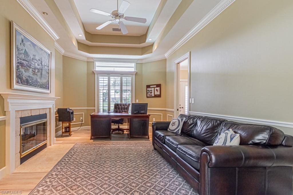 6974 Green Tree Drive Naples, FL 34108 - Photo 19 of 32 a living room with furniture fireplace and flat screen tv