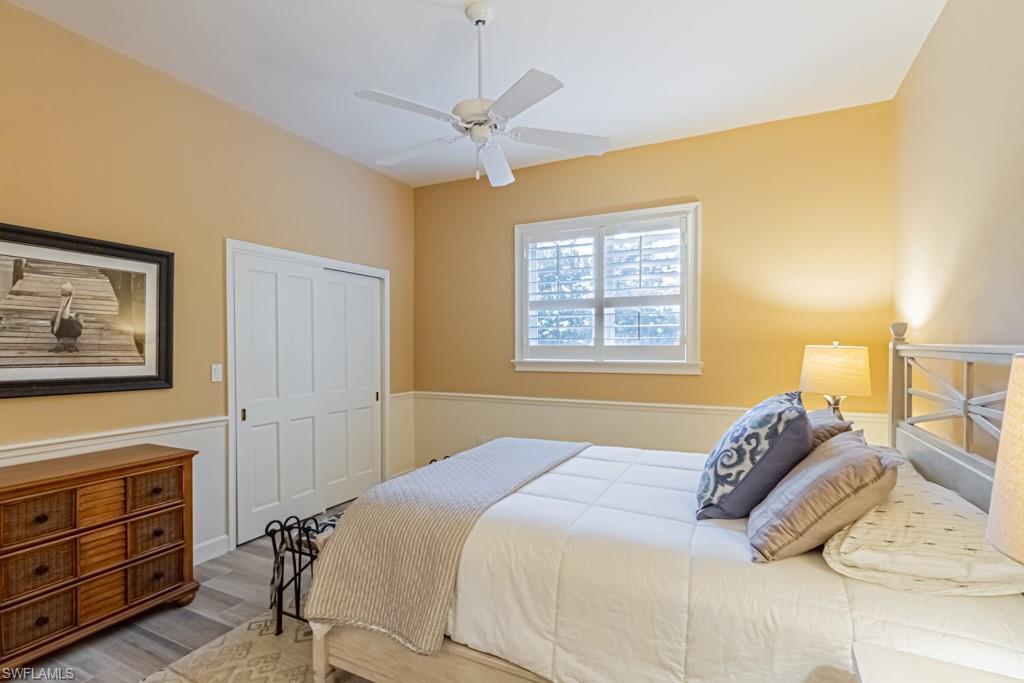 6974 Green Tree Drive Naples, FL 34108 - Photo 21 of 32 a bedroom with a bed and a chandelier