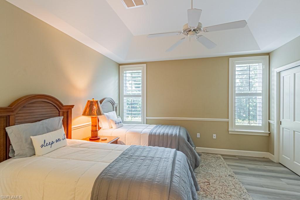 6974 Green Tree Drive Naples, FL 34108 - Photo 22 of 32 a bedroom with a bed and wooden floor