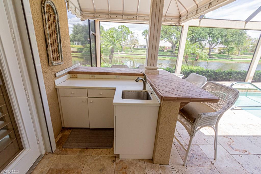 6974 Green Tree Drive Naples, FL 34108 - Photo 25 of 32 a room that has a bed and a table chair