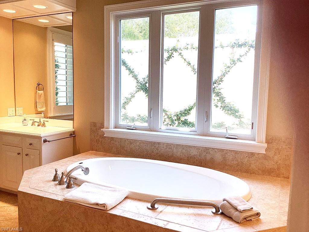 6974 Green Tree Drive Naples, FL 34108 - Photo 31 of 32 a bath tub sitting in a bathroom next to a window
