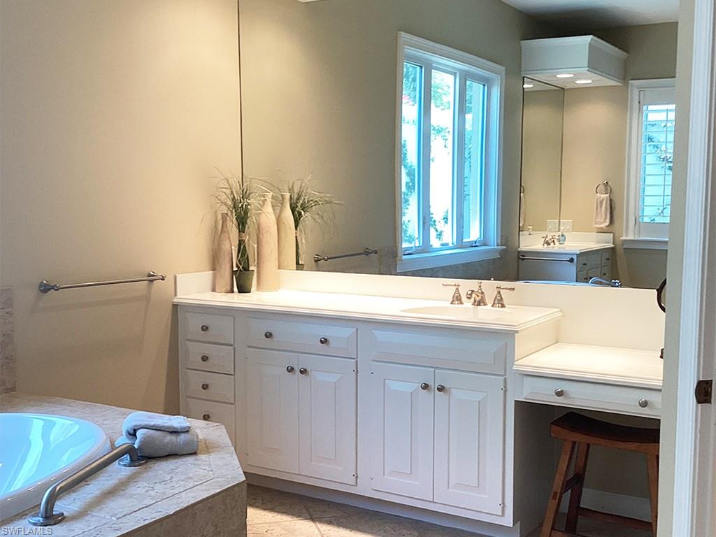 6974 Green Tree Drive Naples, FL 34108 - Photo 32 of 32 a bathroom with a sink and a mirror