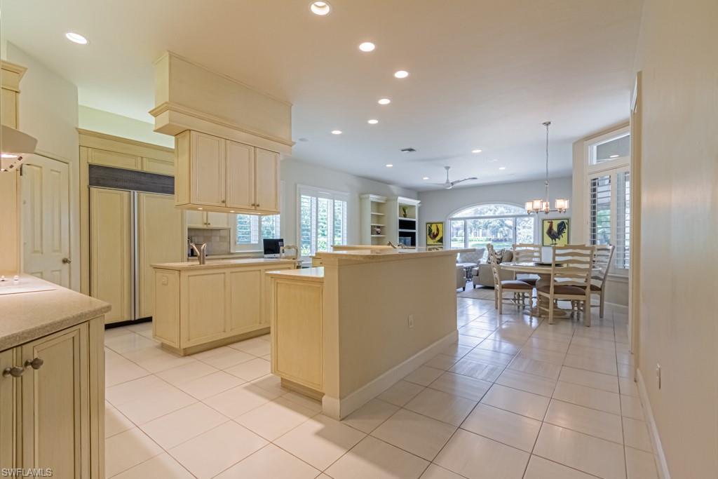 6974 Green Tree Drive Naples, FL 34108 - Photo 10 of 32 a kitchen with cabinets and chairs