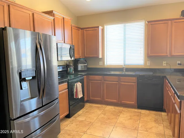 a kitchen with granite countertop a refrigerator and a sink