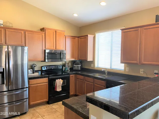 a kitchen with granite countertop a sink stainless steel appliances and cabinets