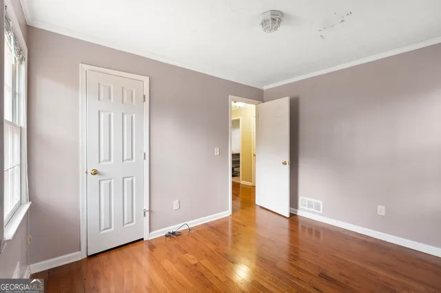 a view of an empty room with wooden floor