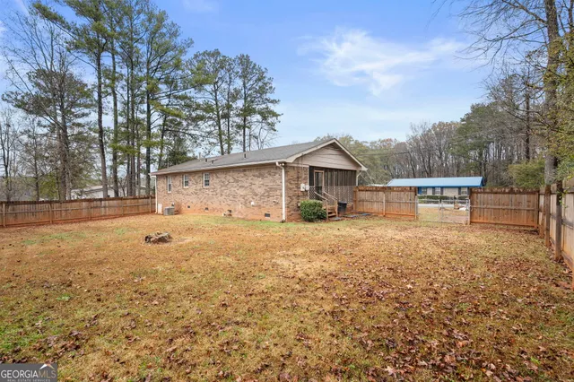 a front view of house with yard and trees in the background