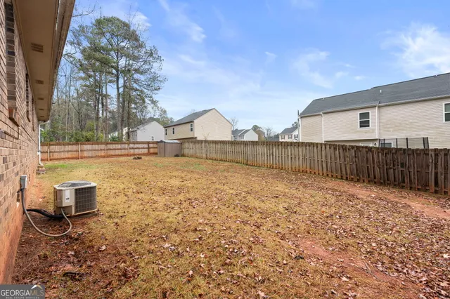 a view of a backyard with wooden fence